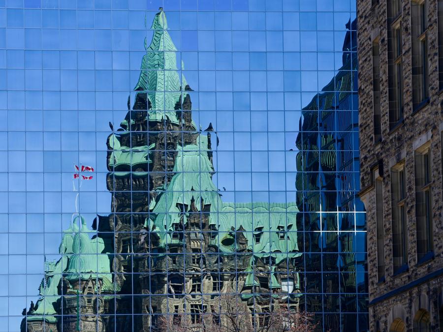 The Confederation Building reflects off the windows of a building in downtown Ottawa on April 7, 2020. Sean Kilpatrick/The Canadian Press